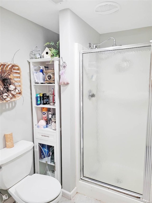 bathroom with toilet and a shower with shower door