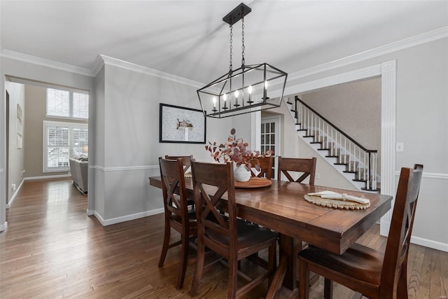 dining room featuring ornamental molding, stairway, wood finished floors, and baseboards