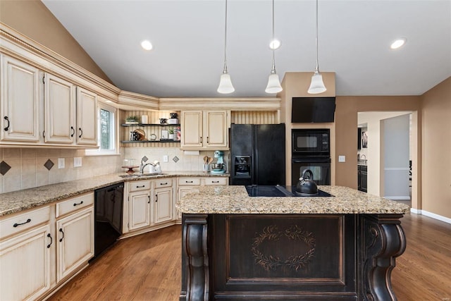 kitchen featuring lofted ceiling, open shelves, a sink, cream cabinetry, and black appliances