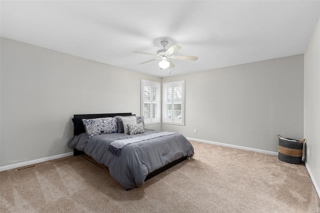 carpeted bedroom with visible vents, baseboards, and ceiling fan