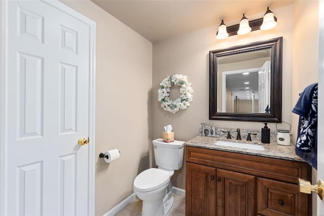 bathroom with baseboards, vanity, toilet, and tile patterned floors