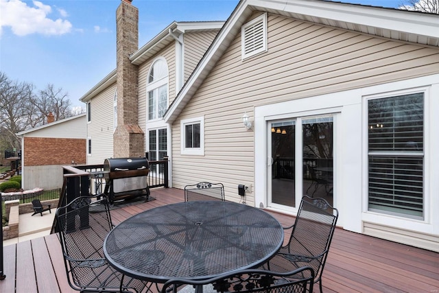 deck with a grill and outdoor dining space