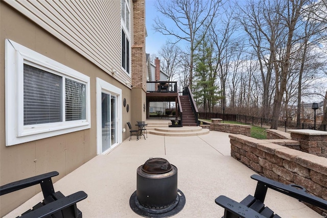 view of patio with fence and stairway