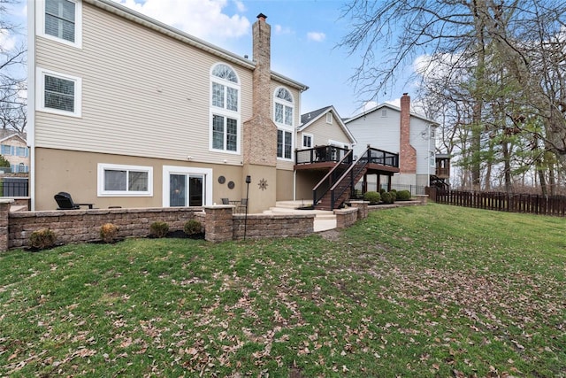 rear view of property with fence, stairs, a yard, a chimney, and a patio area