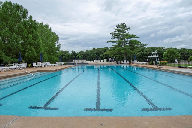 community pool with fence and a patio