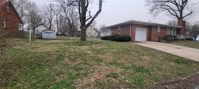 view of yard featuring a shed, fence, an outdoor structure, concrete driveway, and a garage