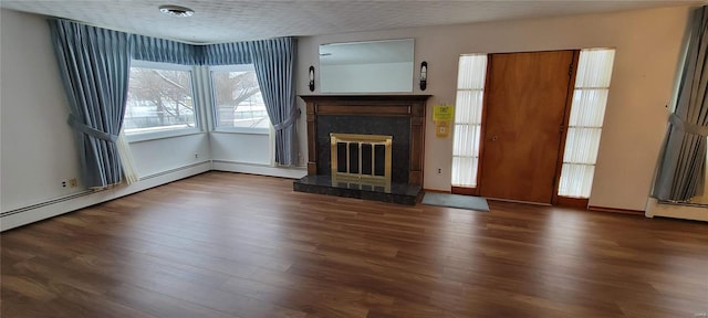 unfurnished living room featuring wood finished floors, visible vents, a high end fireplace, and a textured ceiling