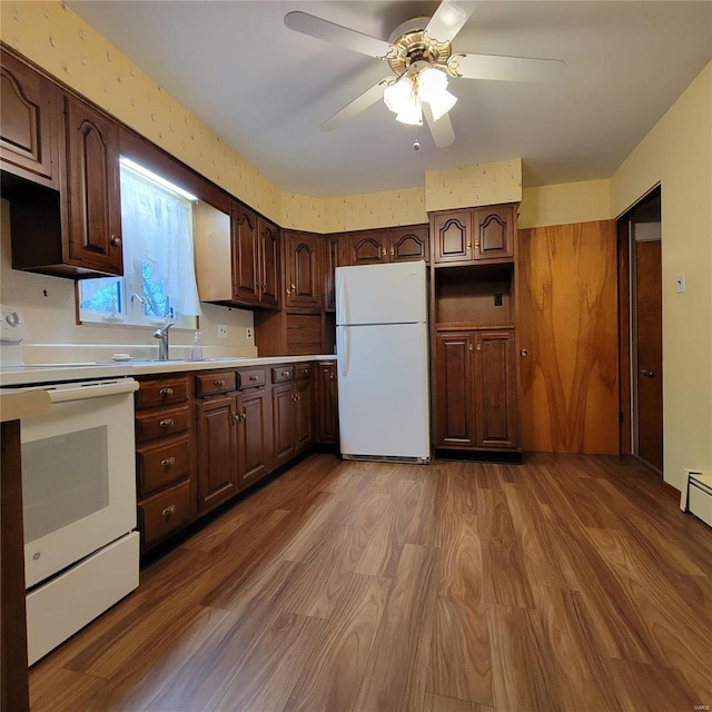 kitchen with ceiling fan, white appliances, dark brown cabinetry, and wood finished floors