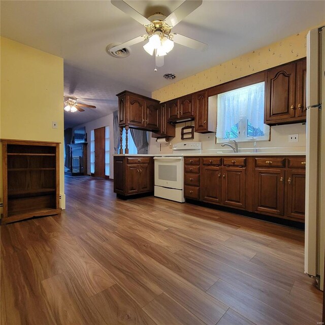 kitchen featuring white appliances, light countertops, dark brown cabinets, ceiling fan, and dark wood-style flooring