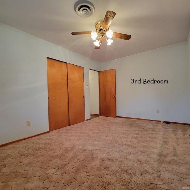 unfurnished bedroom with a closet, baseboards, visible vents, and carpet floors