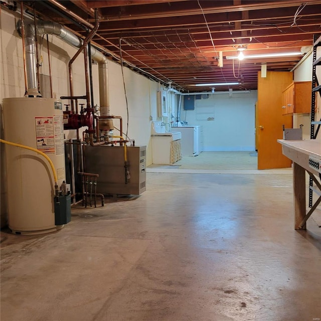 unfinished below grade area with washer and clothes dryer and gas water heater