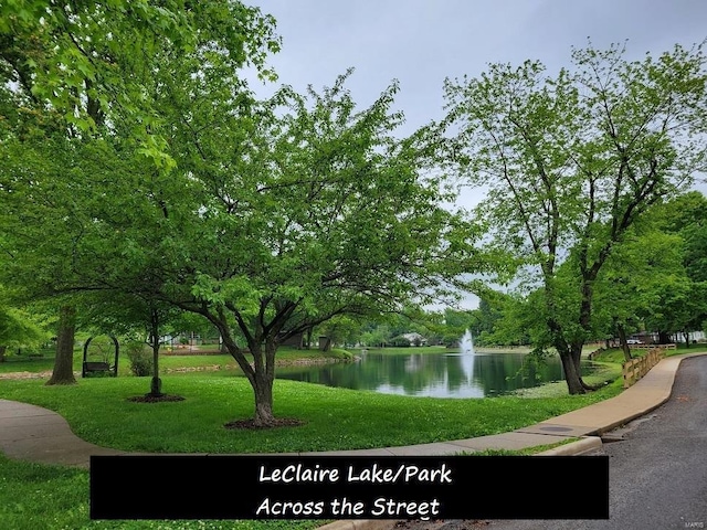 view of community with a yard and a water view