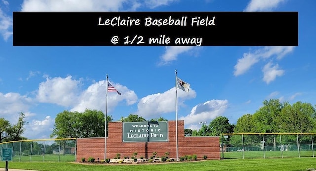 community sign featuring a lawn and fence