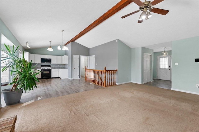 unfurnished living room featuring ceiling fan, lofted ceiling with beams, and carpet