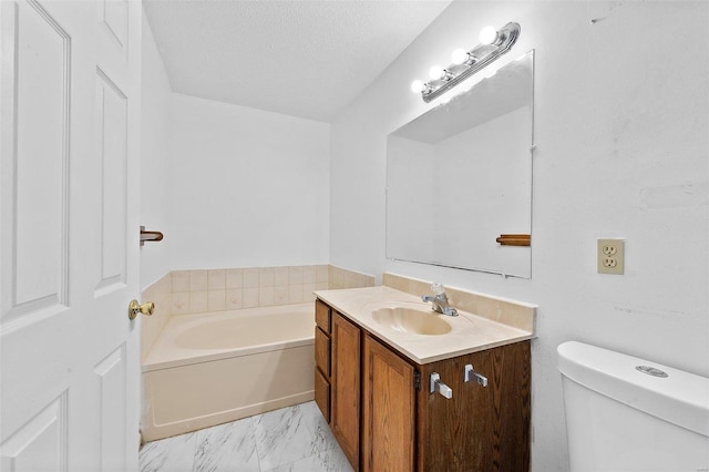 bathroom featuring a textured ceiling, a tub, vanity, and toilet