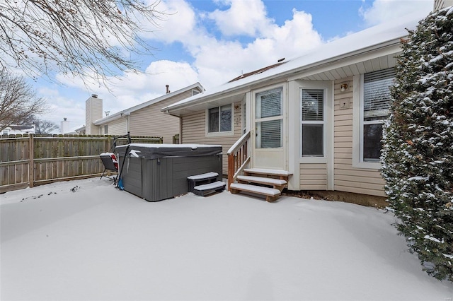 snow covered property with a hot tub