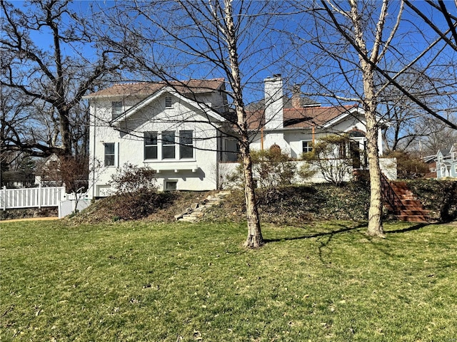 view of front of property featuring a chimney, a front yard, and stucco siding