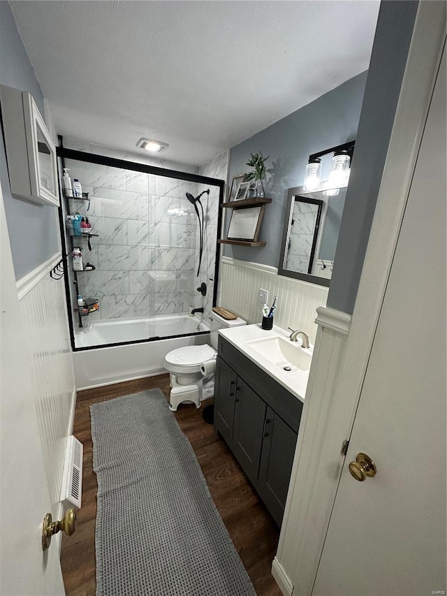 full bathroom featuring vanity, hardwood / wood-style flooring, toilet, and tiled shower / bath