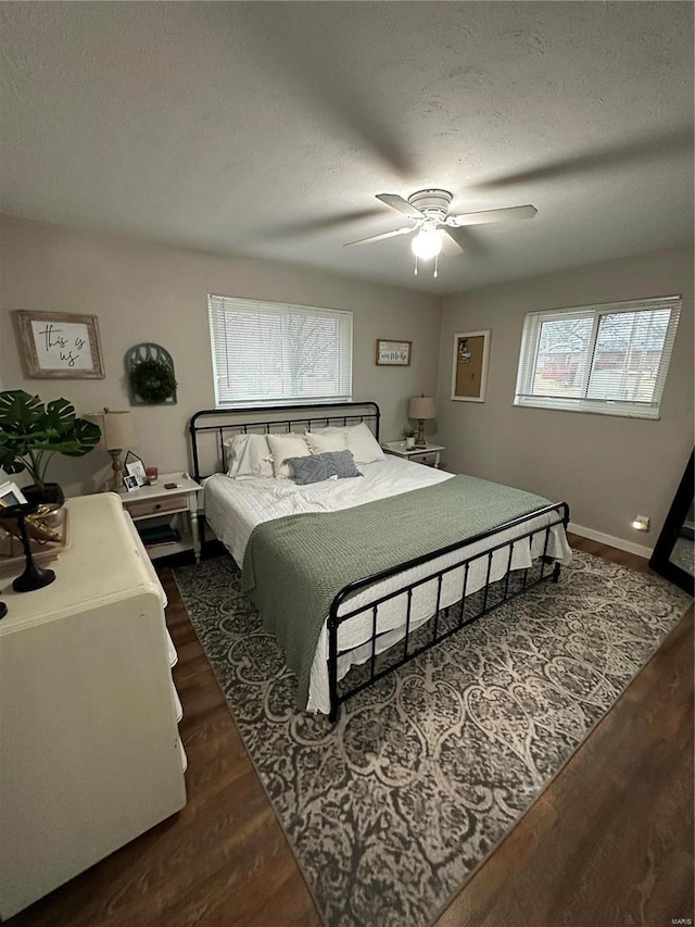 bedroom featuring dark wood-type flooring, ceiling fan, and a textured ceiling