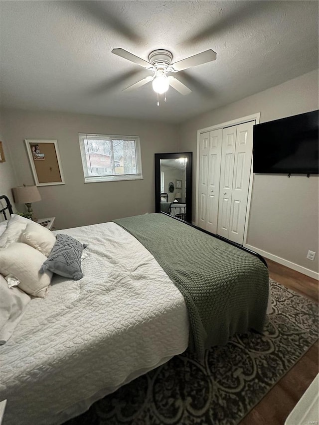 bedroom featuring ceiling fan, wood-type flooring, a closet, and a textured ceiling