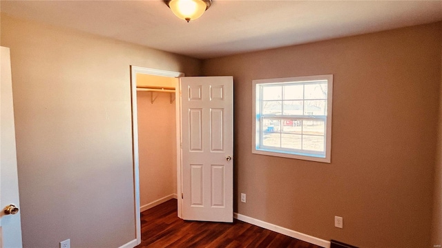 unfurnished bedroom with dark hardwood / wood-style floors and a closet