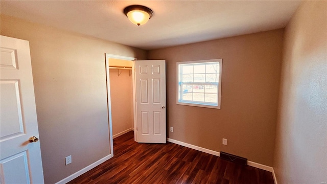 unfurnished bedroom featuring a closet and dark hardwood / wood-style floors