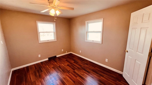 empty room with dark wood-type flooring and ceiling fan