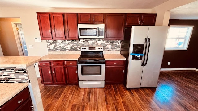 kitchen with tasteful backsplash, dark hardwood / wood-style floors, and appliances with stainless steel finishes