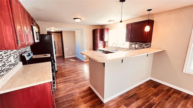 kitchen featuring a breakfast bar, pendant lighting, tasteful backsplash, sink, and dark hardwood / wood-style flooring