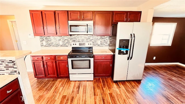 kitchen featuring tasteful backsplash, light wood-type flooring, and appliances with stainless steel finishes