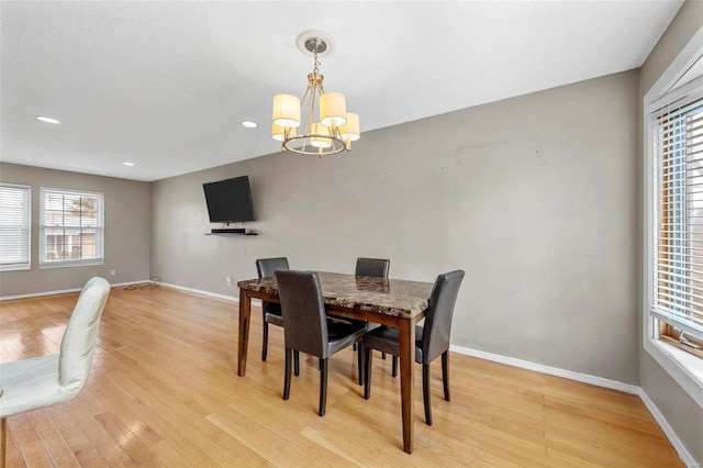 dining room with recessed lighting, baseboards, light wood finished floors, and an inviting chandelier