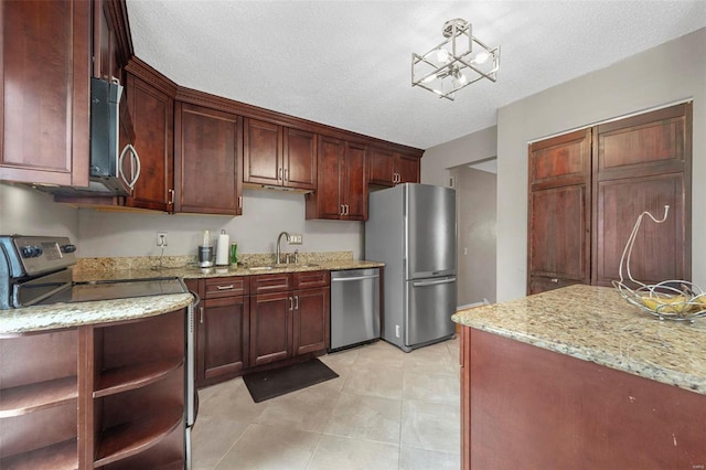 kitchen featuring a textured ceiling, stainless steel appliances, a sink, light stone countertops, and open shelves