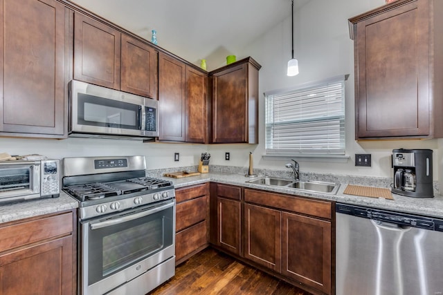 kitchen featuring dark hardwood / wood-style flooring, sink, decorative light fixtures, and appliances with stainless steel finishes