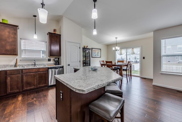 kitchen featuring pendant lighting, dishwasher, sink, a center island, and dark wood-type flooring