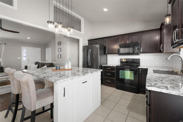 kitchen with decorative backsplash, open floor plan, a center island, a sink, and black appliances