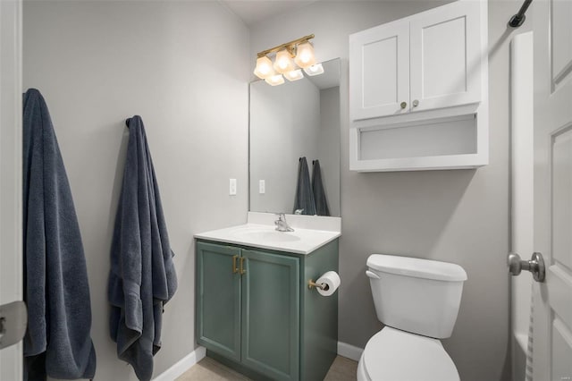 bathroom with baseboards, vanity, and toilet
