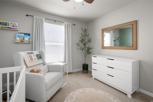 sitting room with baseboards, light carpet, and a ceiling fan