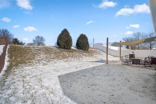 yard covered in snow featuring a patio and fence