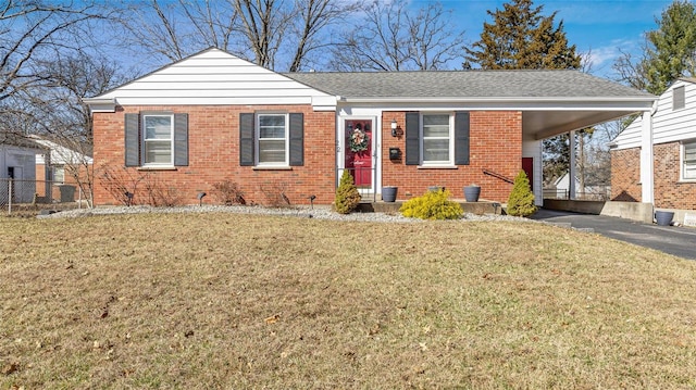 view of front of home with a front lawn, a carport, brick siding, and driveway