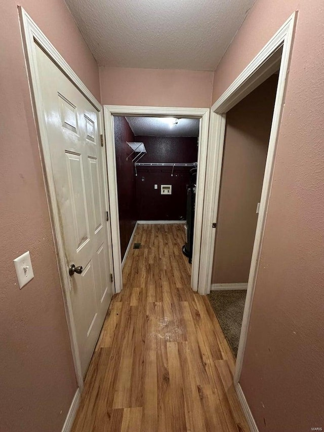 hallway featuring a textured ceiling and light wood-type flooring