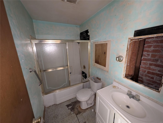 full bathroom with enclosed tub / shower combo, vanity, and toilet