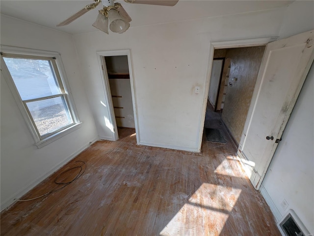 unfurnished bedroom with a spacious closet, light hardwood / wood-style flooring, a closet, and ceiling fan