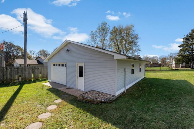 rear view of property with a yard, a garage, and an outdoor structure