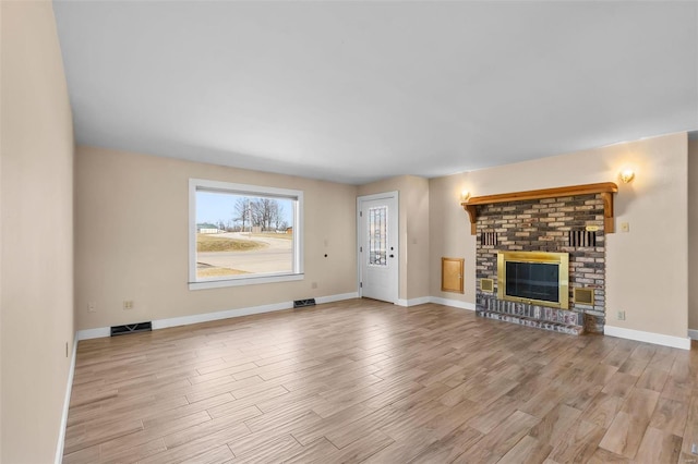 unfurnished living room featuring a fireplace and light hardwood / wood-style floors