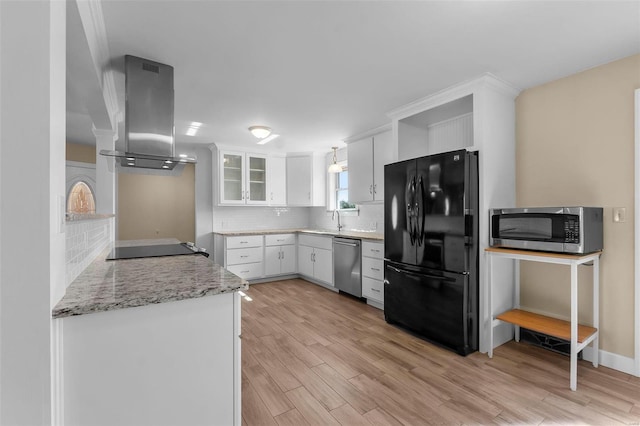 kitchen with island range hood, white cabinets, backsplash, black appliances, and light stone countertops