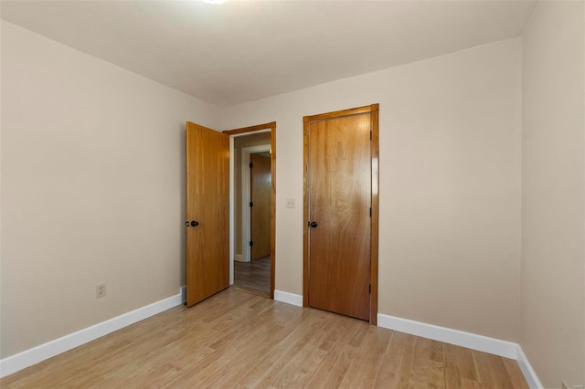 unfurnished bedroom with light wood-type flooring and a closet