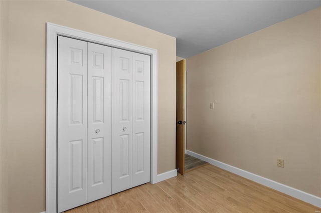 unfurnished bedroom featuring a closet and light hardwood / wood-style flooring