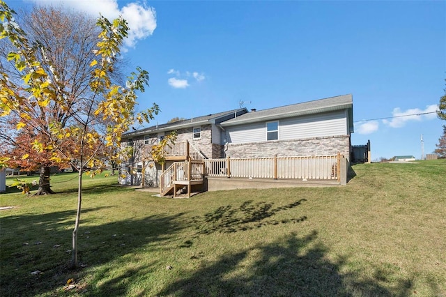 rear view of house featuring a wooden deck and a yard