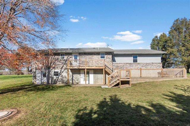 rear view of house with a wooden deck and a lawn