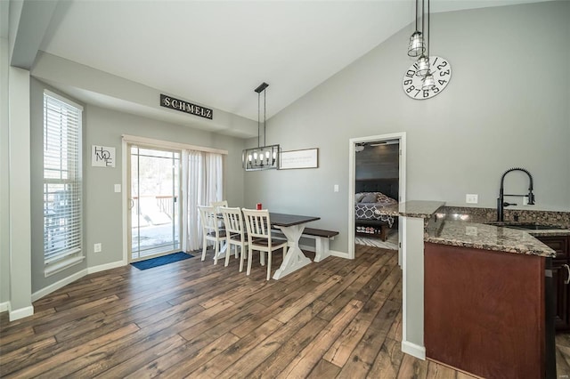 dining space with an inviting chandelier, baseboards, dark wood finished floors, and high vaulted ceiling